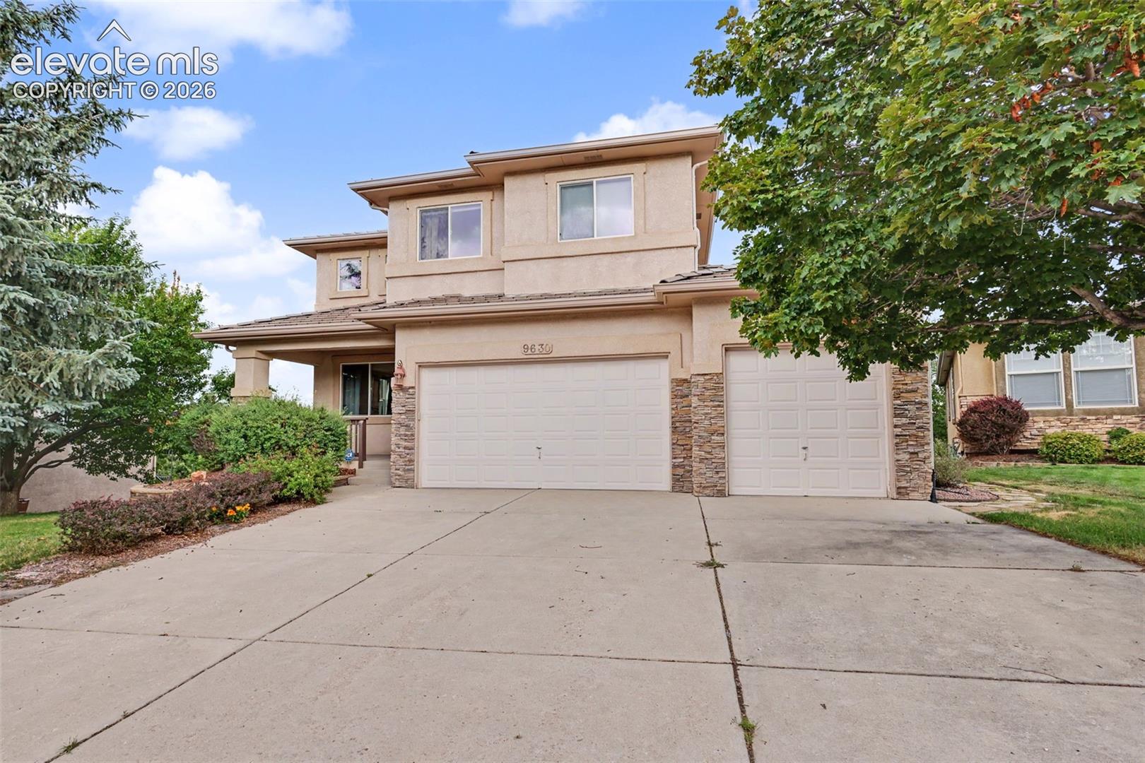 Two-story exterior with stucco siding and stone accents
