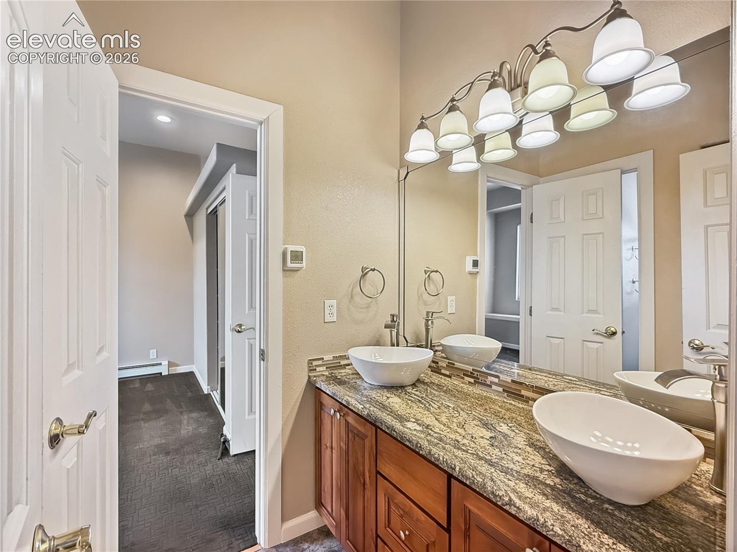 Updated vessel sinks in the jack and jill bath with alder cabinets and granite top