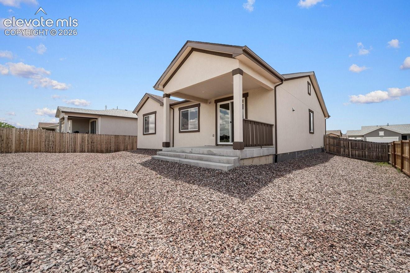 Modern residence featuring a gabled roofline with clean architectural lines, neutral exterior finishes, and a spacious gravel yard