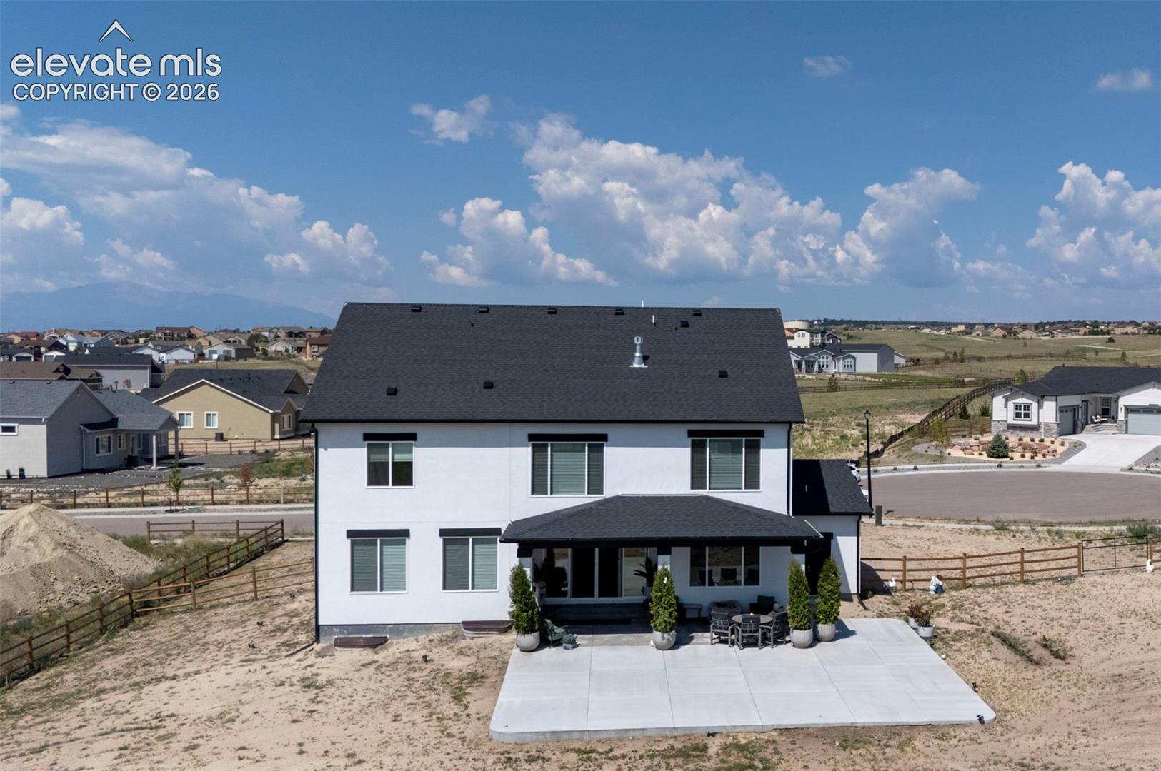 Modern three-story residence featuring a dark shingle roof and white exterior siding