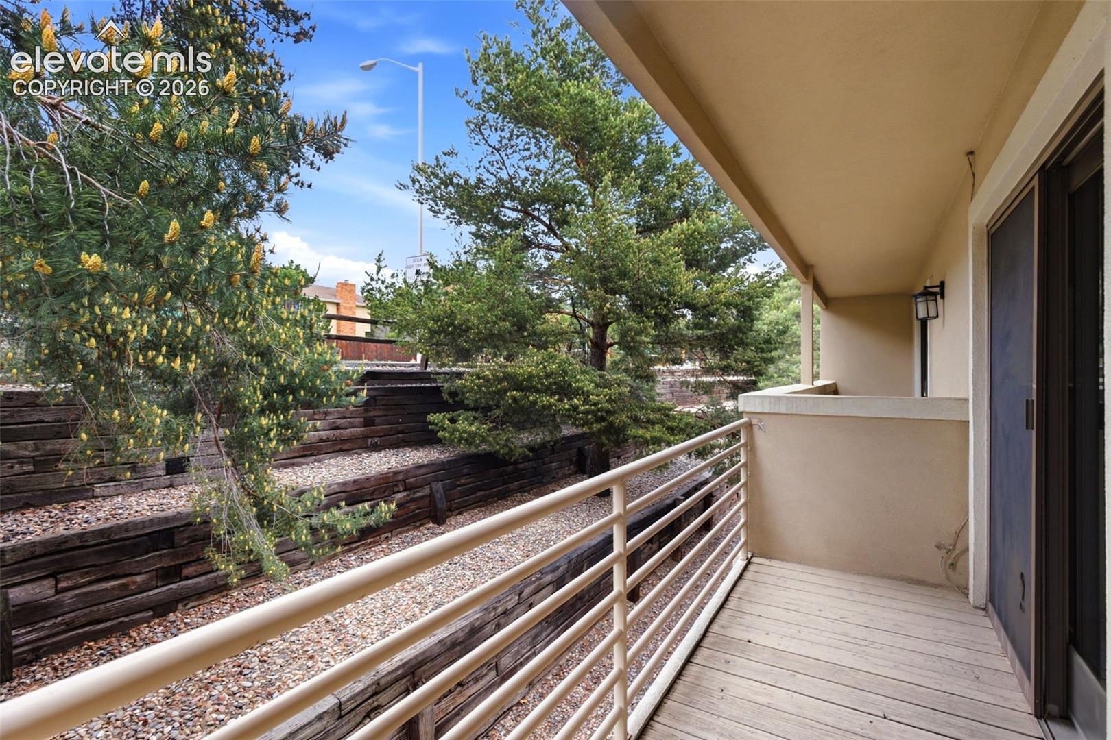 Private balcony featuring wood-finish flooring and a metal railing
