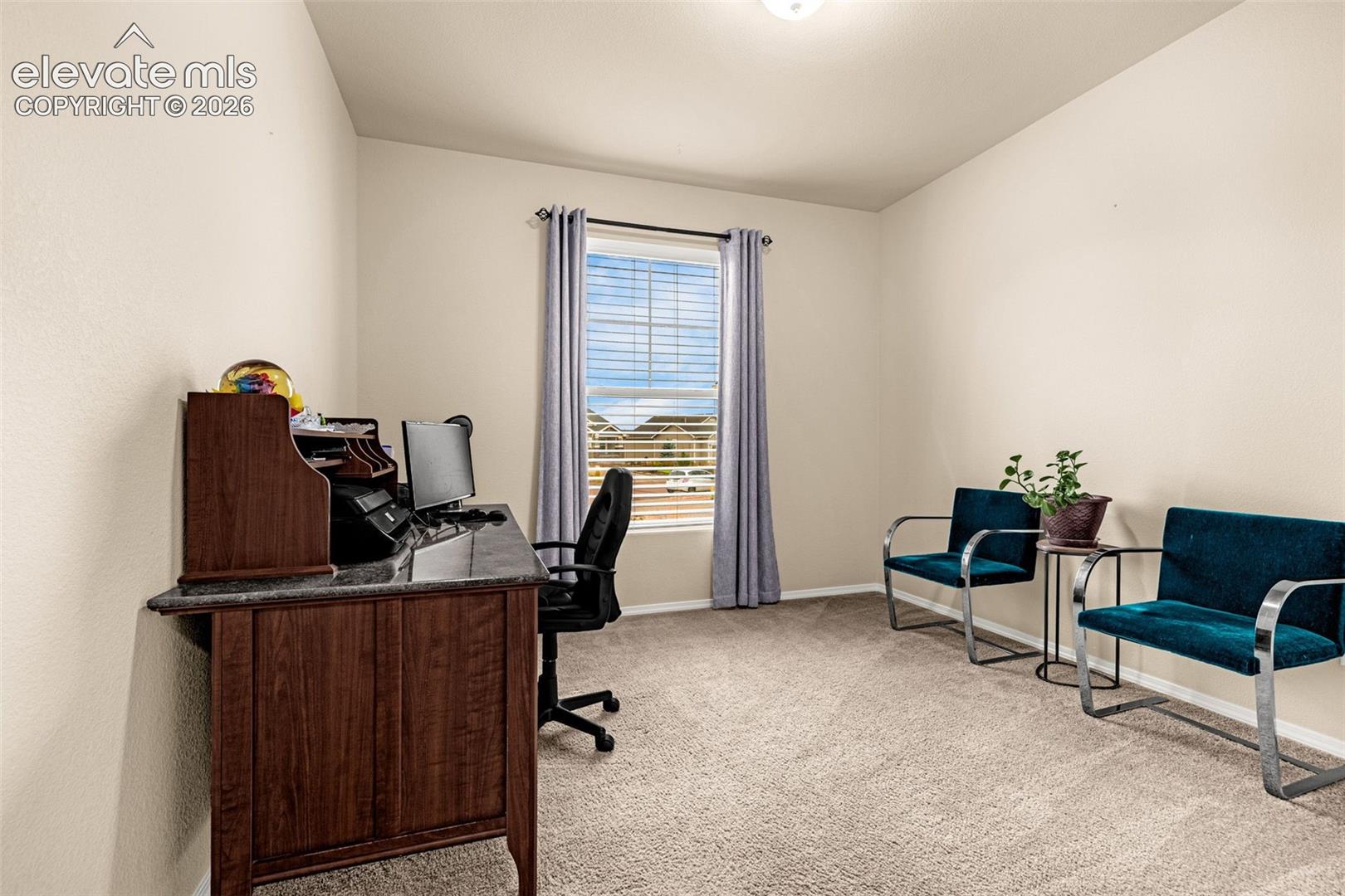 Neutral interior space featuring high-pile carpeting, neutral wall paint, and a single-pane window with adjustable blinds