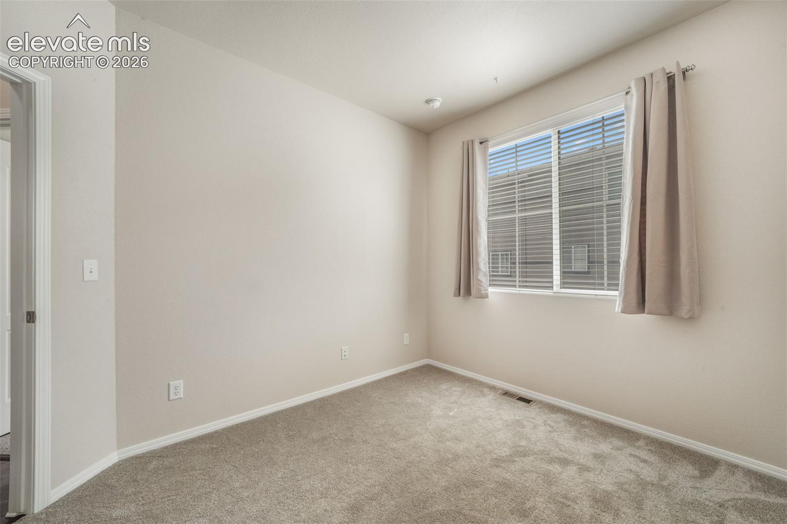 Neutral-toned walls complement the gray carpeting
