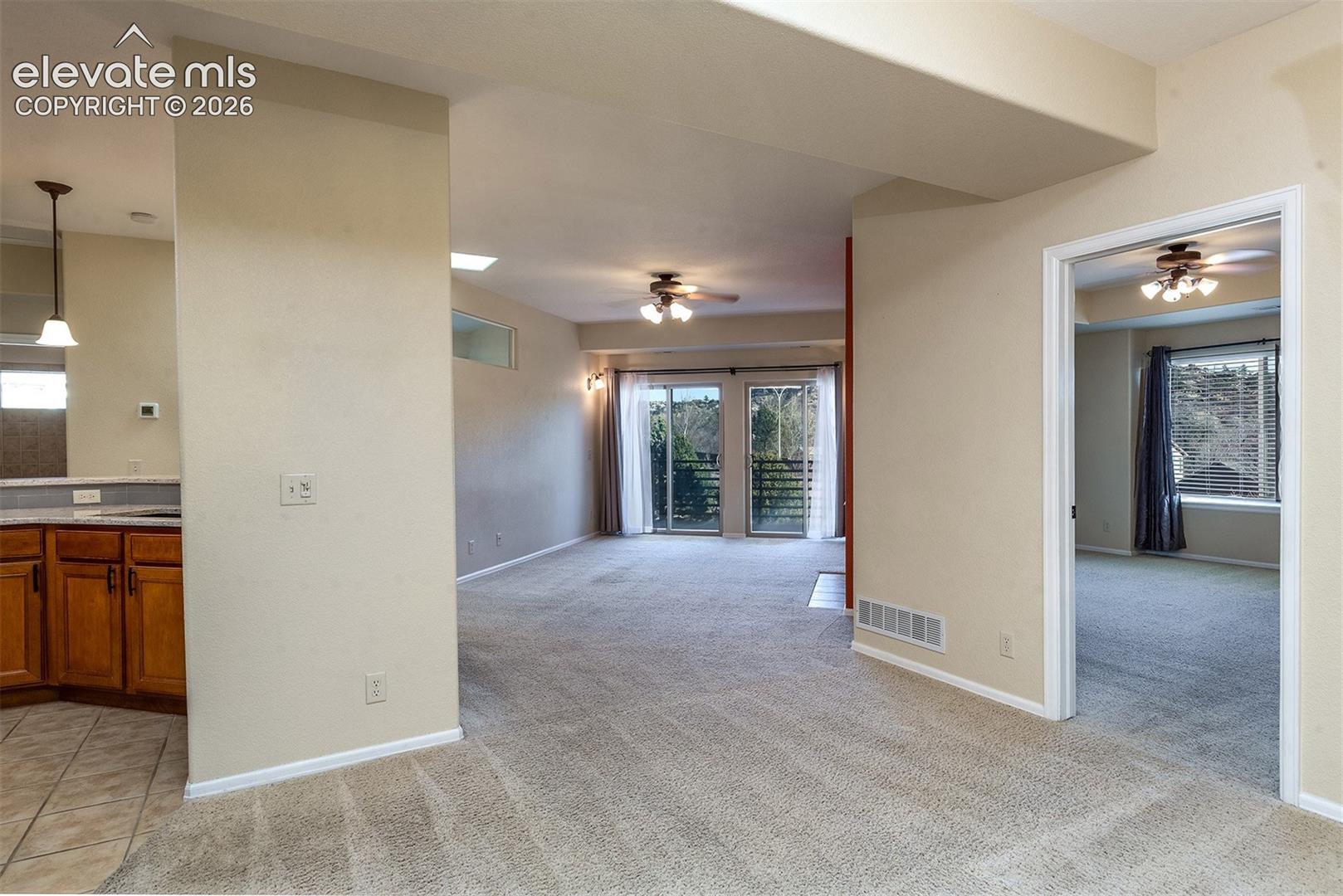 Primary bedroom (right), living area, and kitchen (left) upon entry