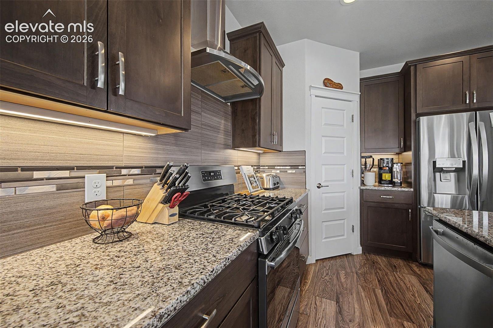The kitchen features a gas range and decorative hood.