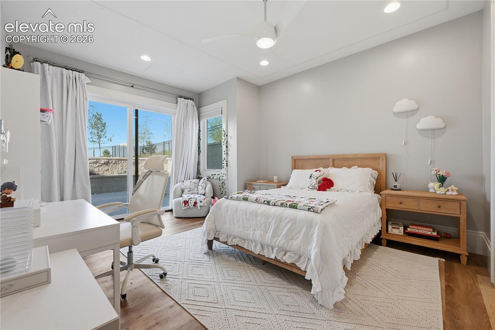 Recessed lighting, wood-finish flooring, ceiling fan with integrated light, and glass sliding door access to exterior space
