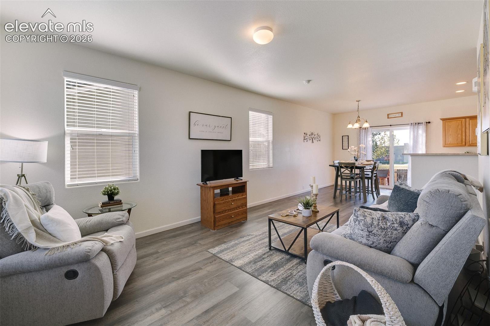 Open-concept living area featuring wood-finish flooring, recessed lighting, and ample natural light