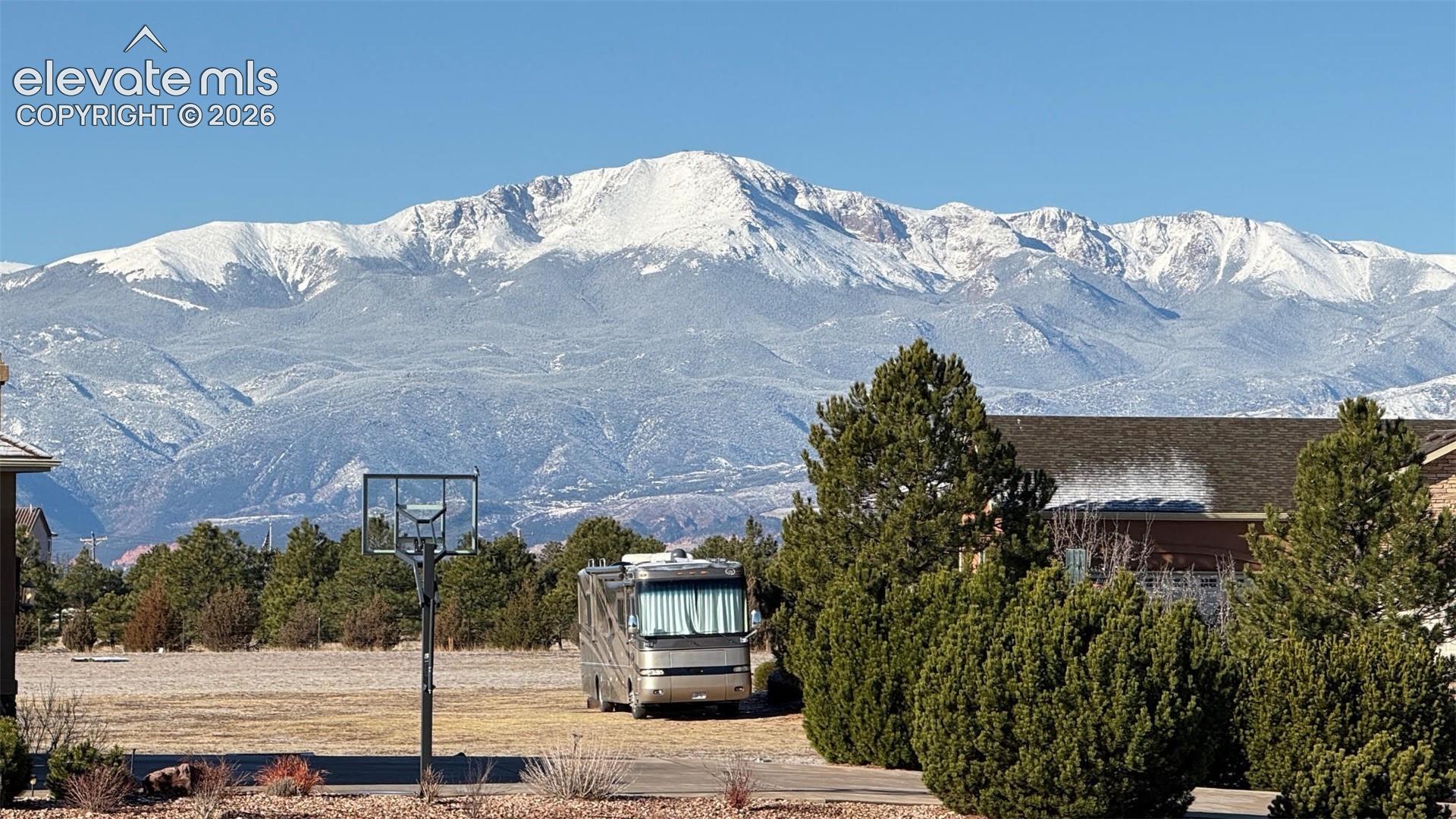 Expansive lot featuring mature evergreen trees and a prominent mountain backdrop