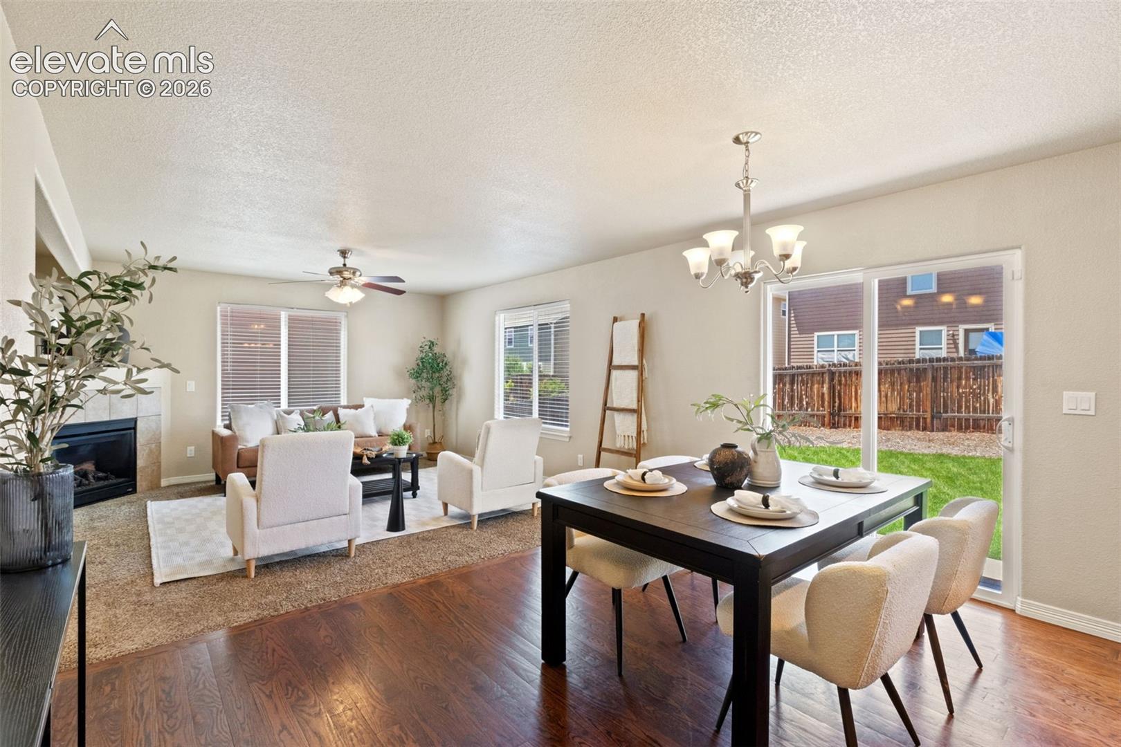 Open-concept living and dining areas featuring wood-finish flooring in the dining space