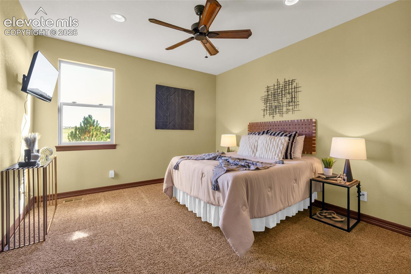 Spacious room featuring neutral wall color, plush carpeting, recessed lighting, and a multi-blade ceiling fan