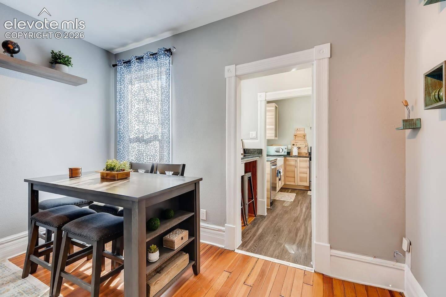 Living room offers space for sitting and dining with tall ceilings and big windows.
