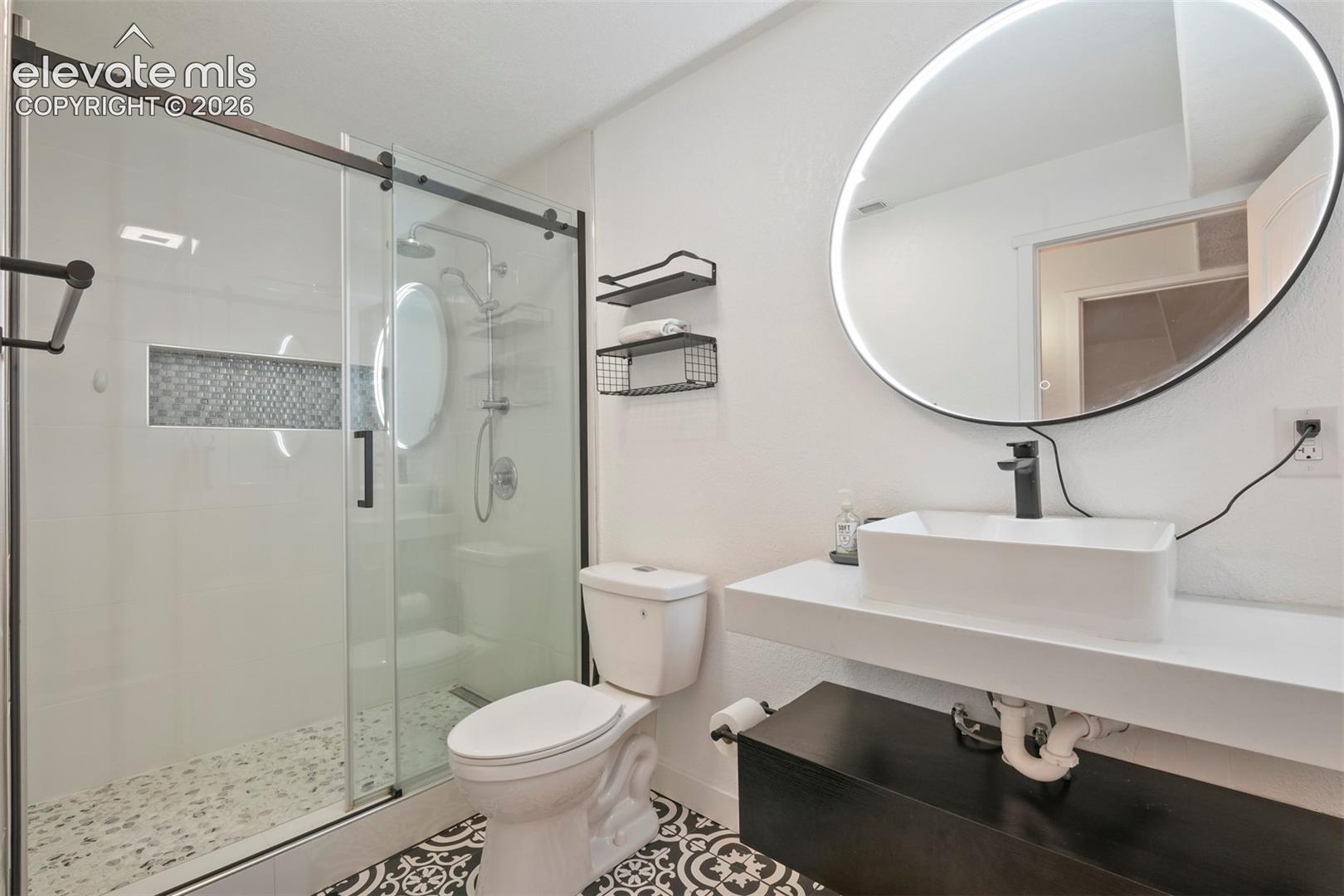 Basement: Modern bathroom featuring a frameless glass shower enclosure with a mosaic tile accent niche