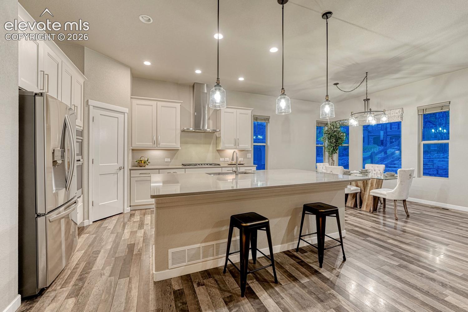 Beautiful kitchen with walk in pantry, oversized bar with seating area and dining area
