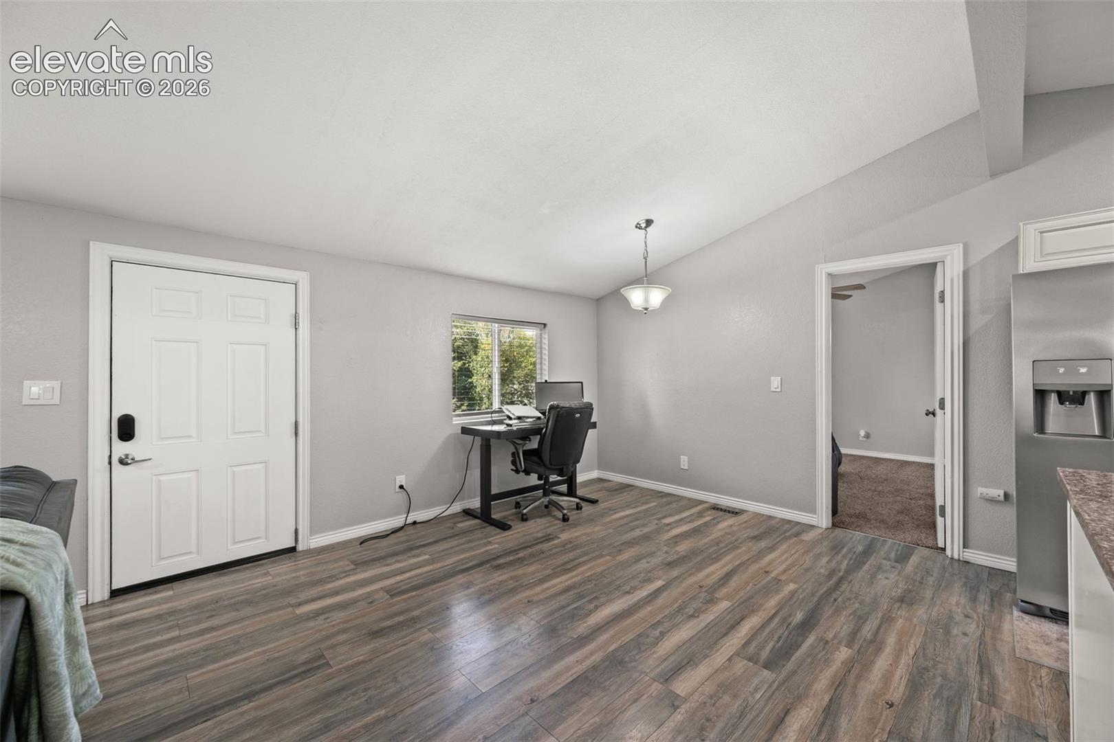 Vaulted ceilings, wood-finish flooring, and a multi-pane window