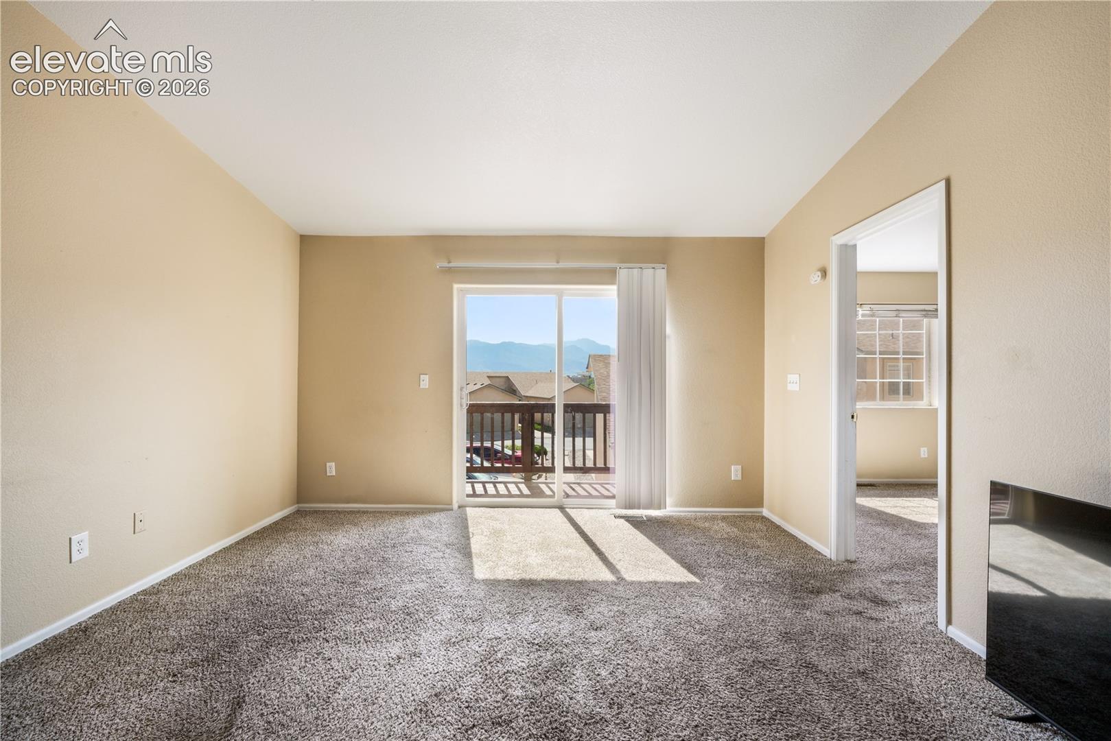 Living room with balcony access and mountain views