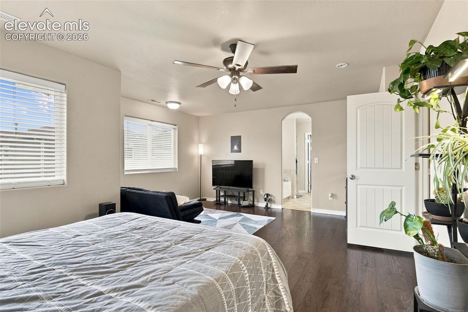 Wood-finish flooring, multi-paneled door, recessed lighting, ceiling fan with light fixture, and arched doorway