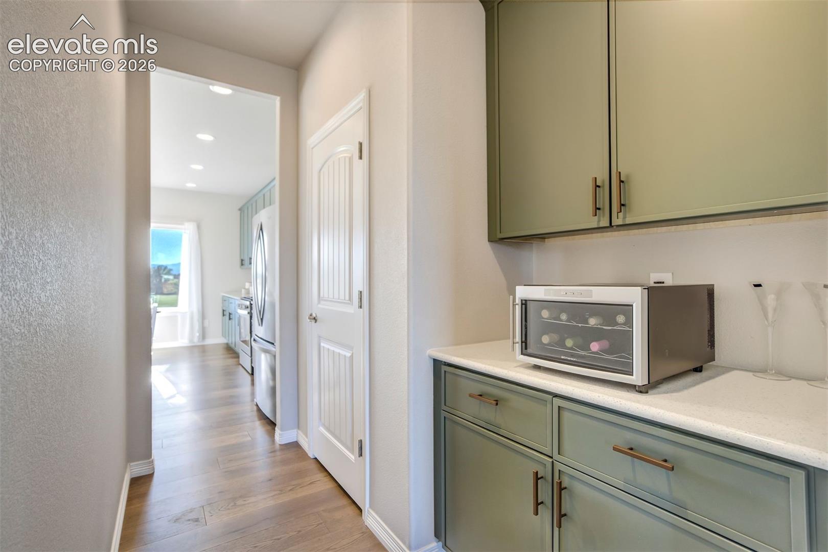 Built-in cabinetry with sage green finish and bronze hardware