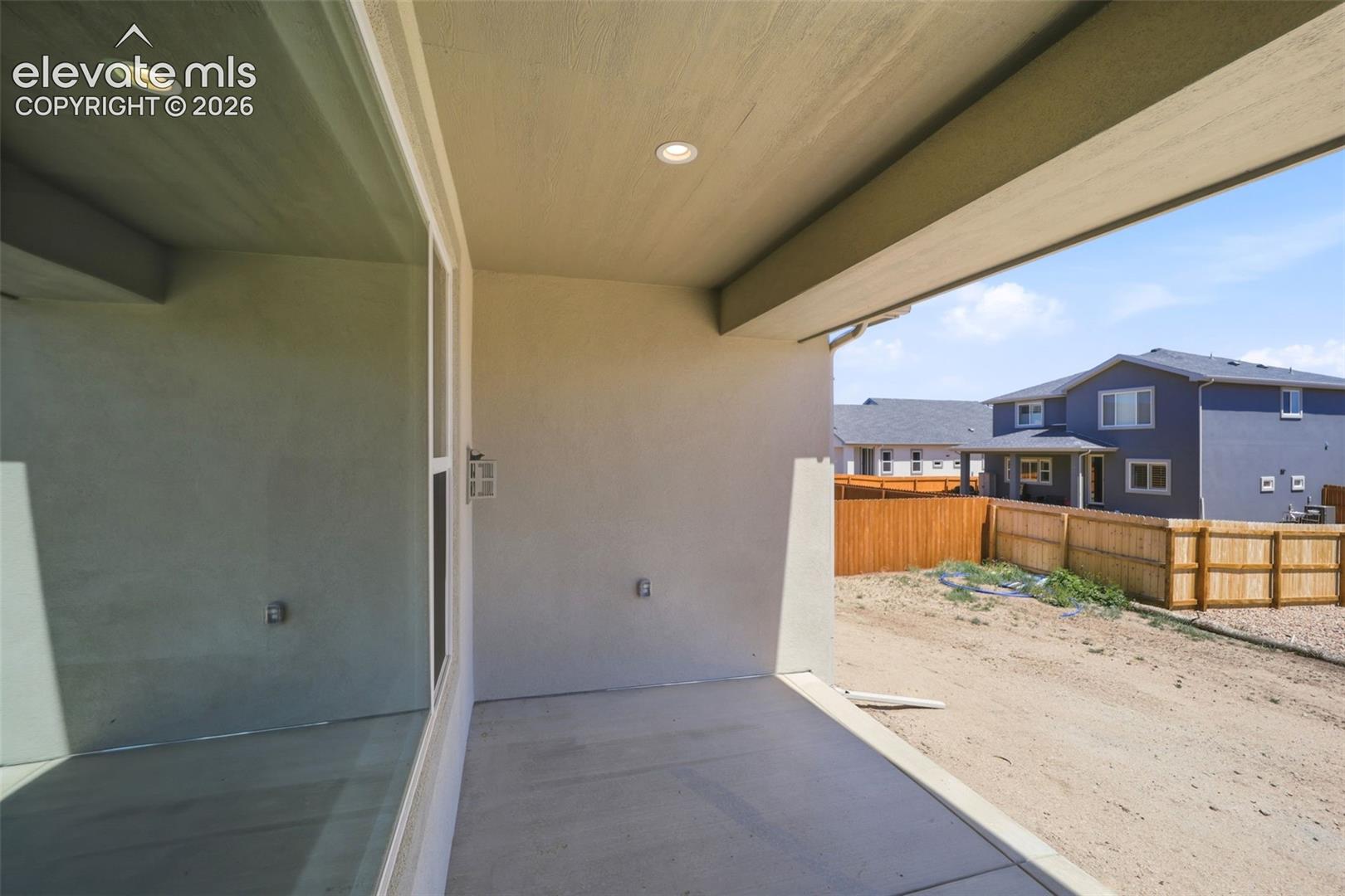 Covered concrete patio featuring recessed lighting and a stucco exterior finish