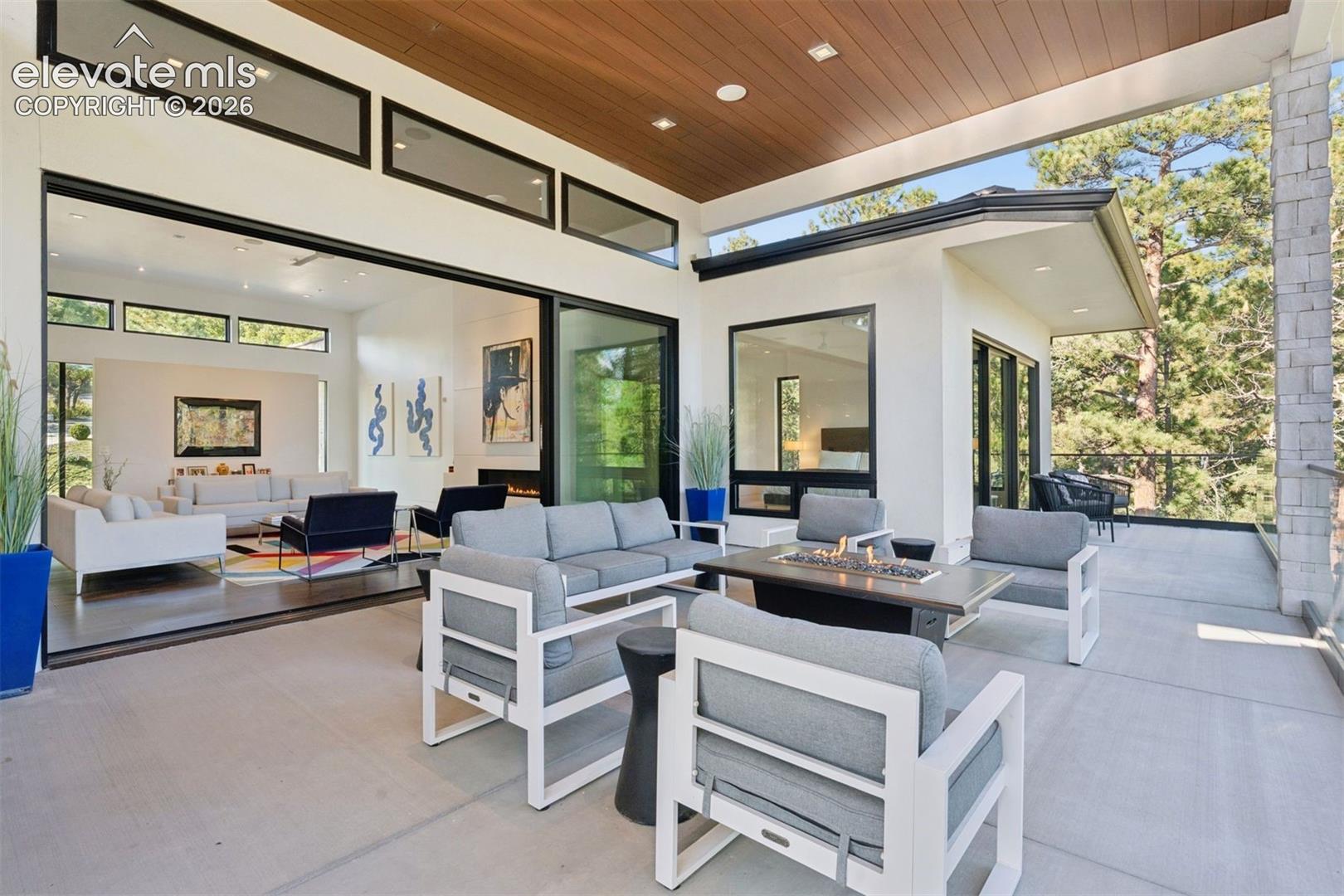 A private outdoor retreat framed by towering pines and the beauty of Colorado's natural landscape. The covered patio offers an inviting place to entertain, unwind beside the fire, or simply enjoy the peaceful setting.
