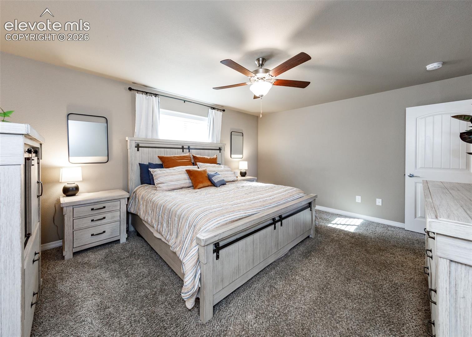 Neutral wall palette with carpeted flooring, window with natural lighting, and ceiling-mounted fan with light fixture