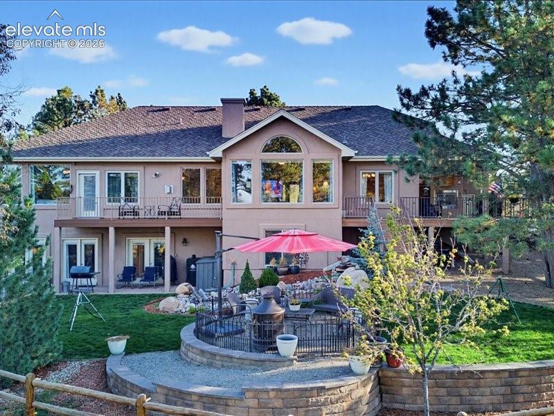 Multi-level exterior featuring a fenced area for children & pets, multiple balconies with wrought iron railings, and extensive windows