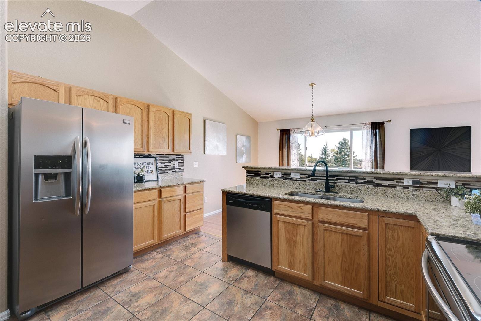 The Kitchen features tile flooring, wood cabinetry with granite countertops and tile backsplash, and stainless steel appliances.