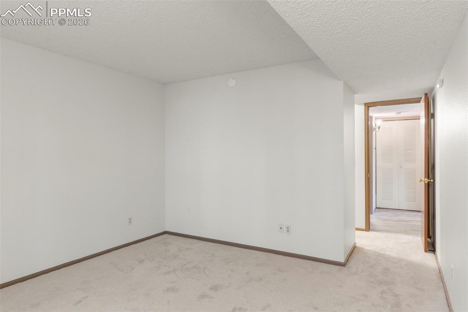Spare room featuring a textured ceiling and light colored carpet