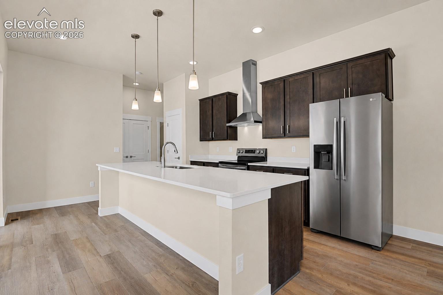 Kitchen offers a large center island, quartz counters, stainless appliances including under counter microwave in island