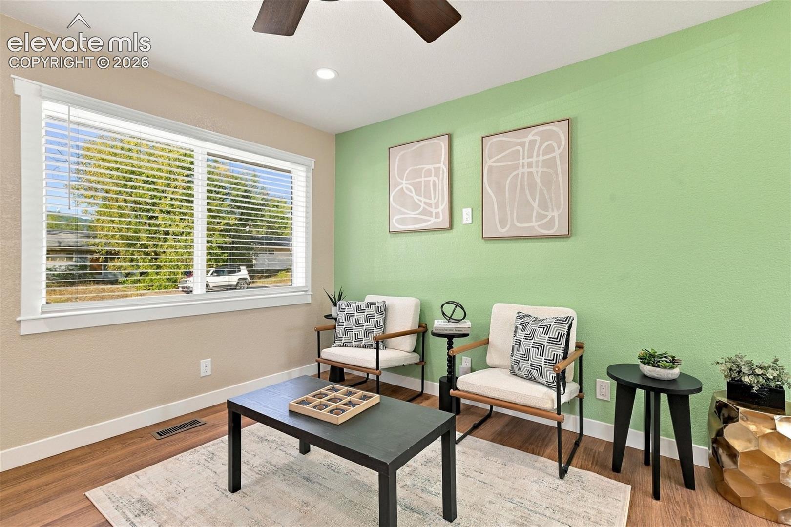 Large window with horizontal blinds, wood-finish flooring, and ceiling fan