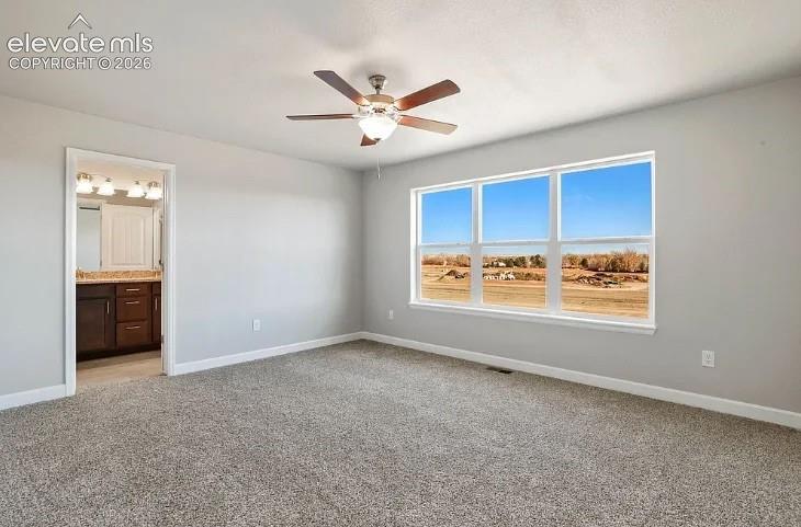 Room featuring neutral wall tones, wall-to-wall carpeting, a multi-blade ceiling fan with integrated lighting, and a large triple-pane window