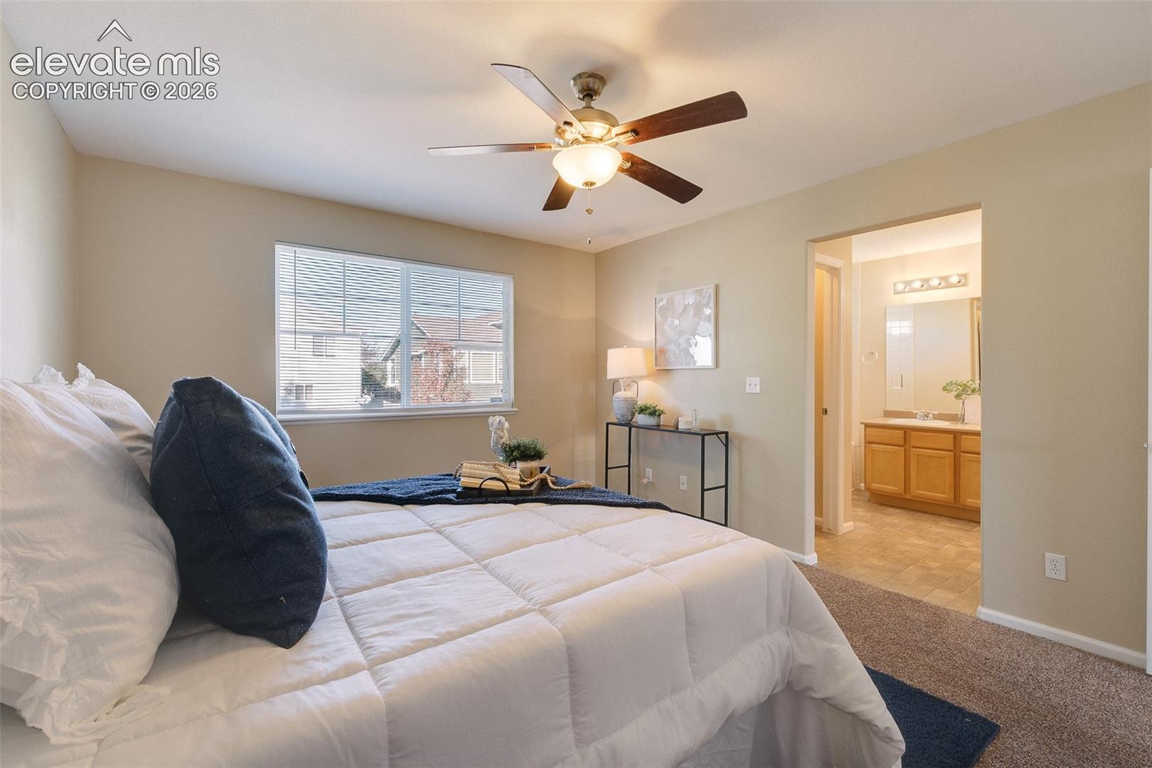 Neutral-toned room featuring a central ceiling fan with integrated lighting, a single-hung window, and wall-to-wall carpeting