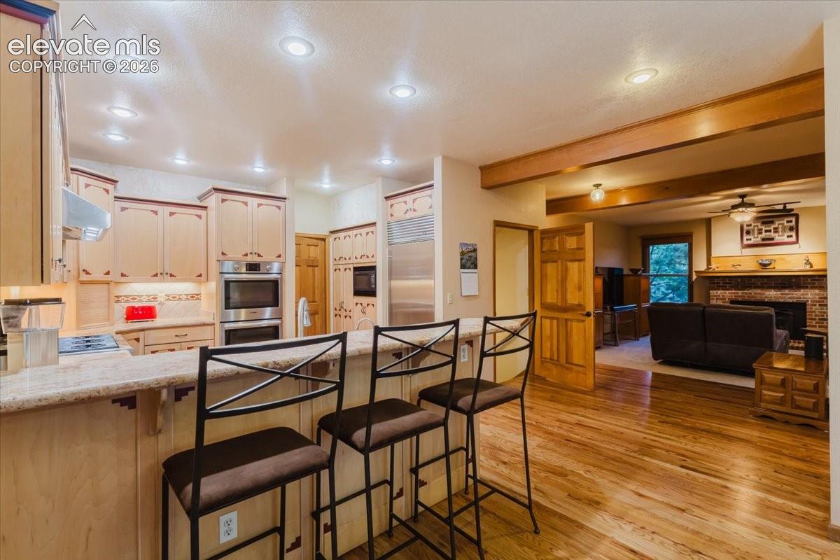 Kitchen featuring a built-in double oven, integrated refrigerator, and a cooktop with a stainless steel range hood