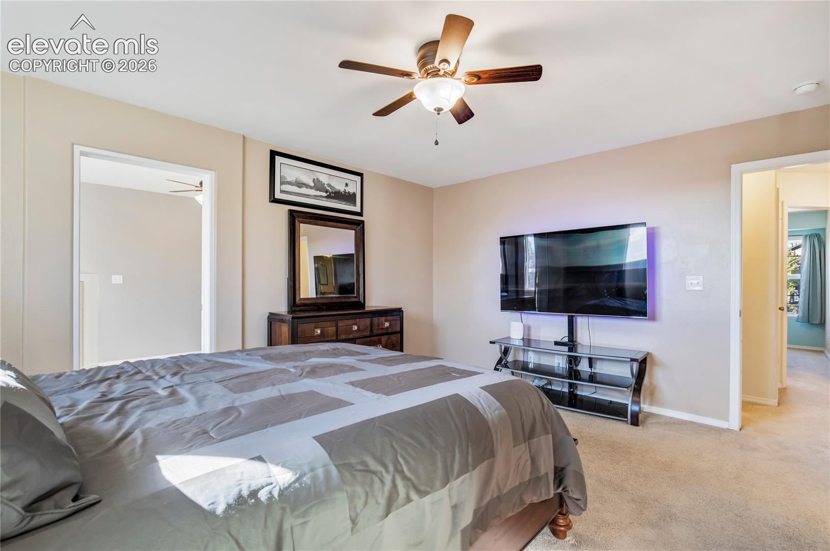 Generous space, natural light + a ceiling fan create a comfortable primary bedroom, with convenient access to the adjoining 5-piece bath.