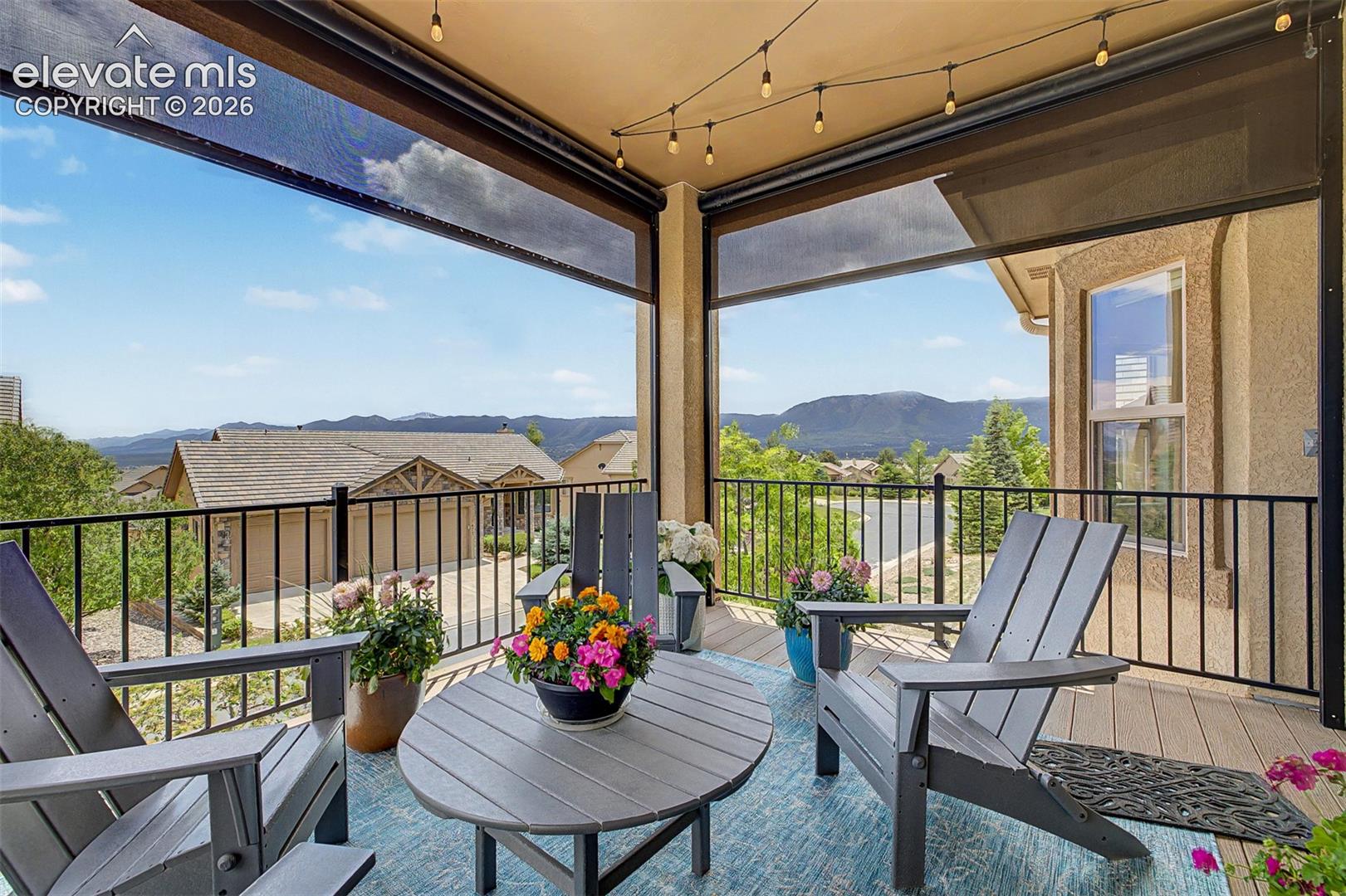 Another view of the large patio with custom remote-controlled blinds with beautiful mountain views and lush trees that makes for a serene peaceful entertaining area, right out the living room and dining area!