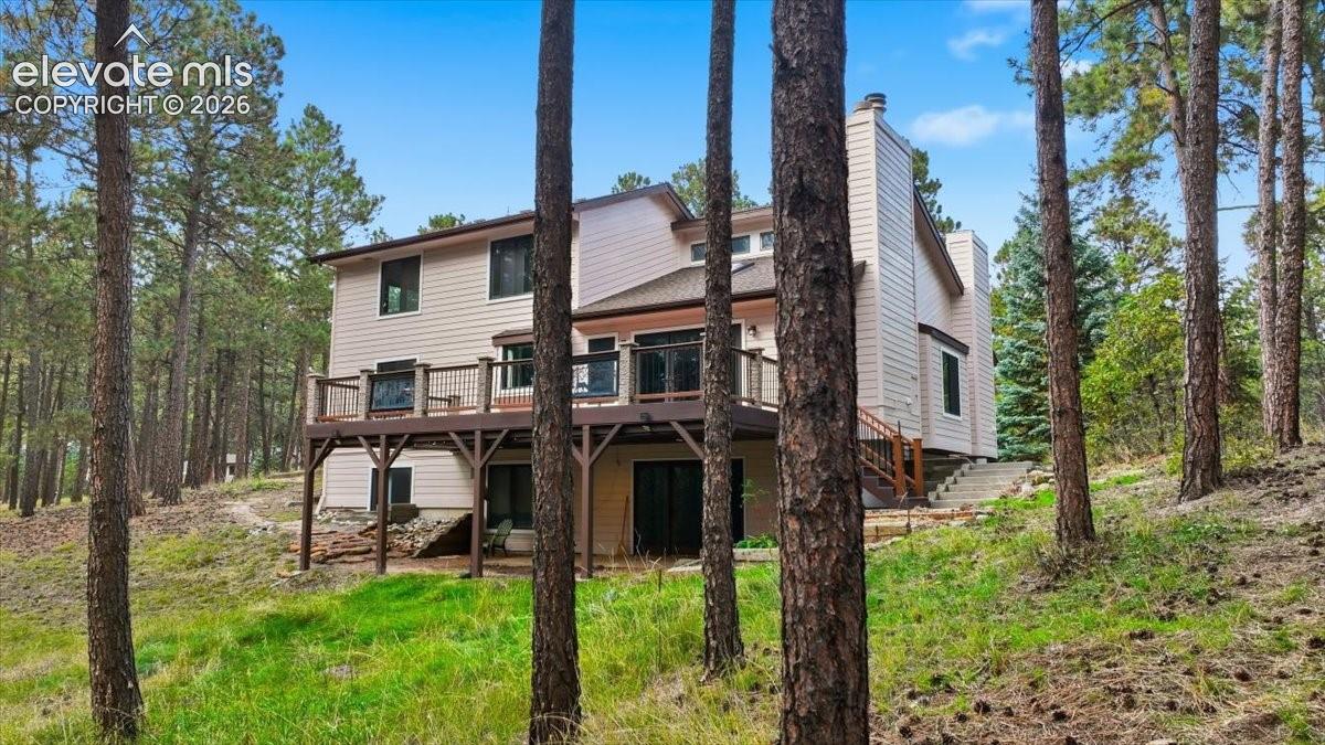 Multi-level exterior with siding, a large elevated deck with metal railings, and a walk-out lower level