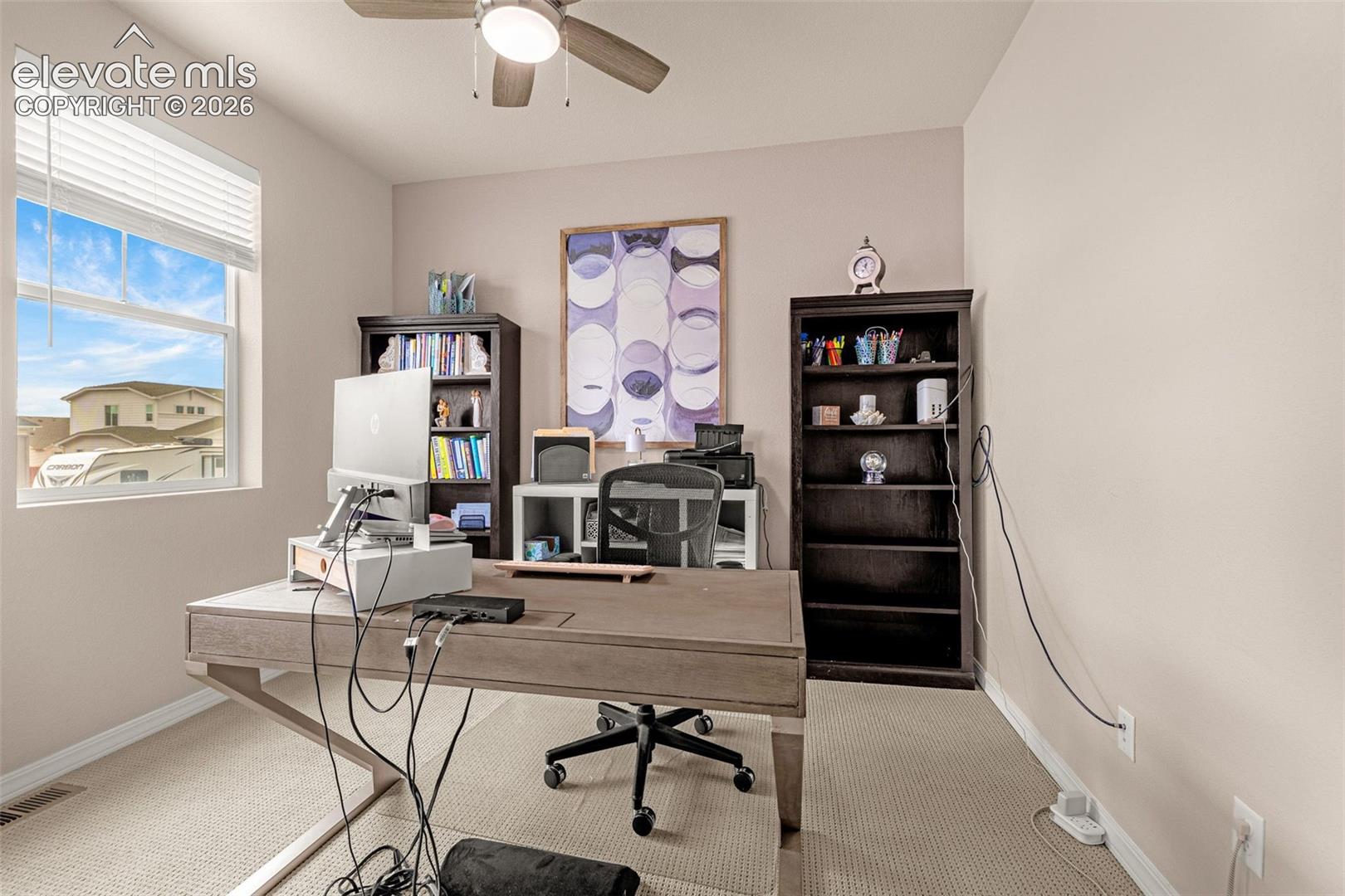 Neutral wall paint, window with blinds, ceiling fan with integrated lighting, and carpet flooring