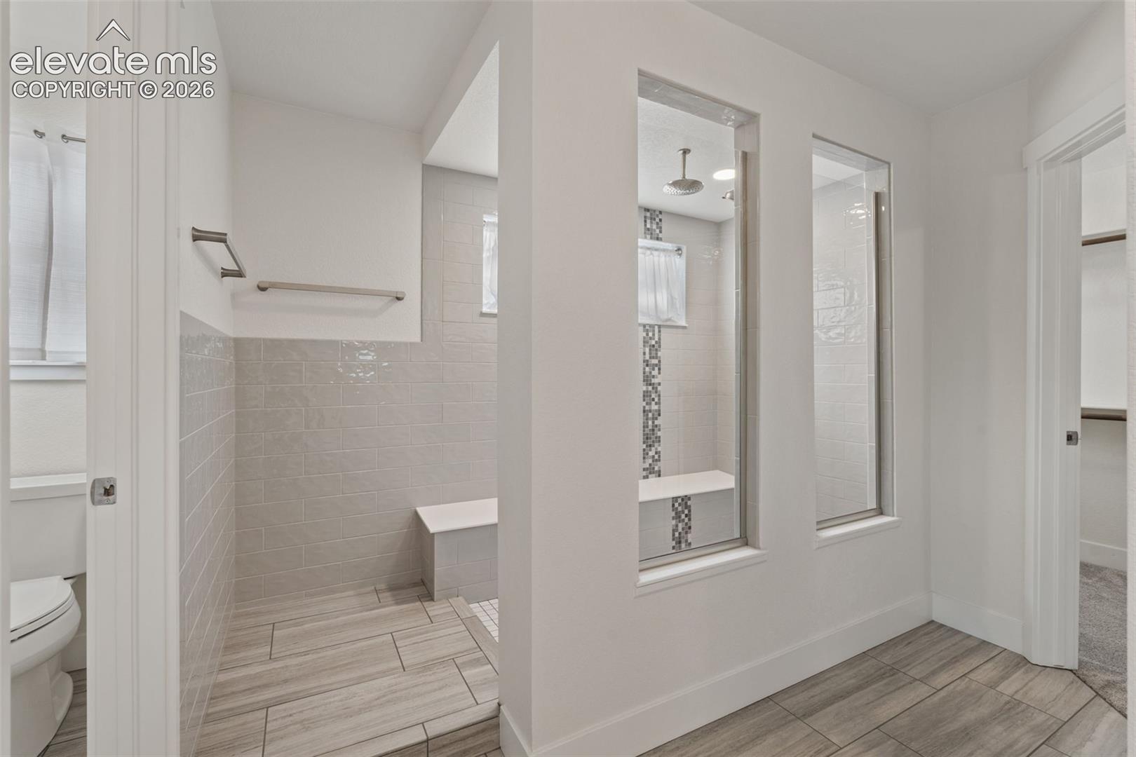 Spa-style walk-in shower with tiled walls and flooring