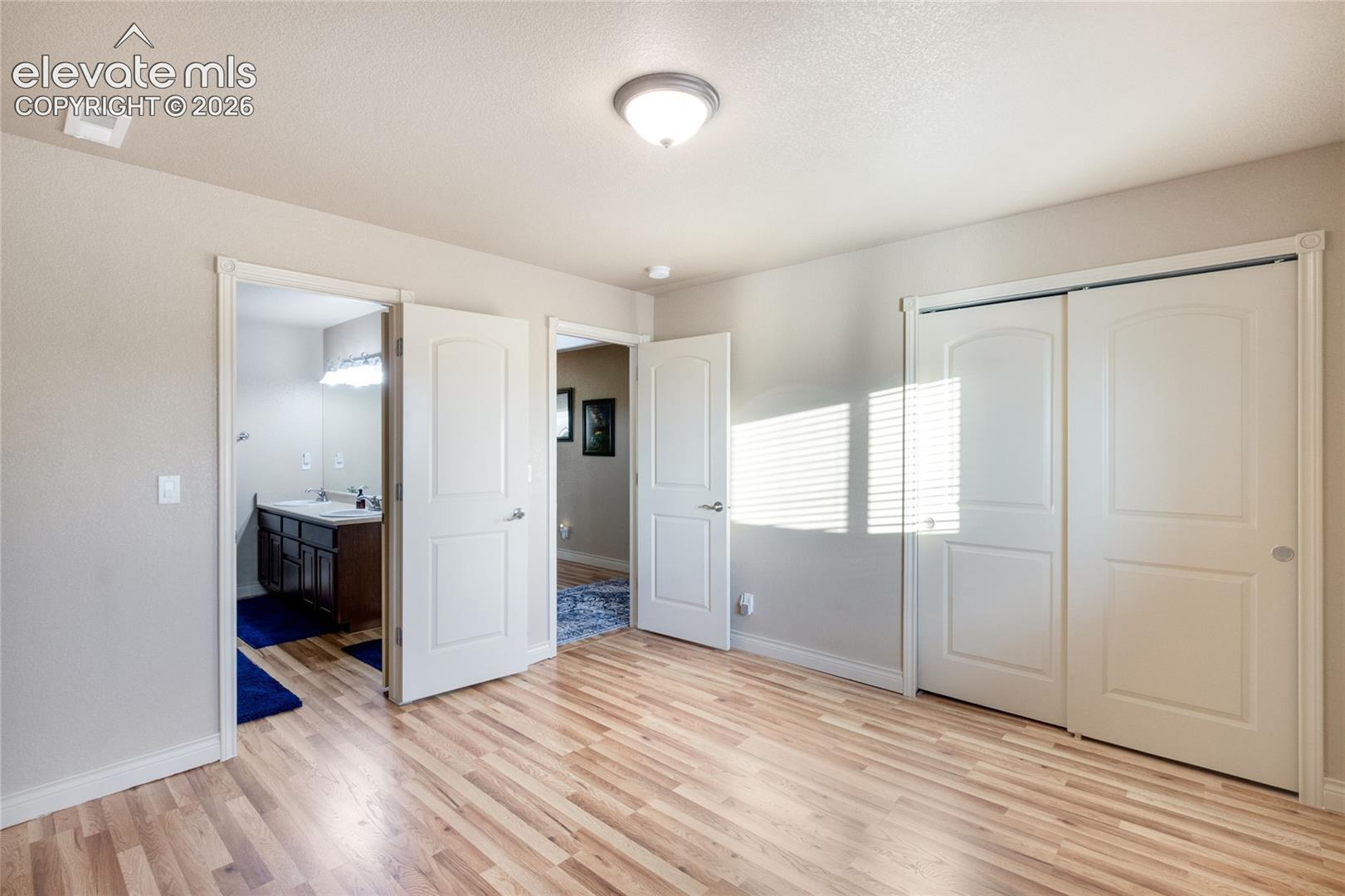 Second Basement Bedroom with Luxury Vinyl Plank, dual-panel interior doors, and a double sliding closet door featuring raised panel detailing