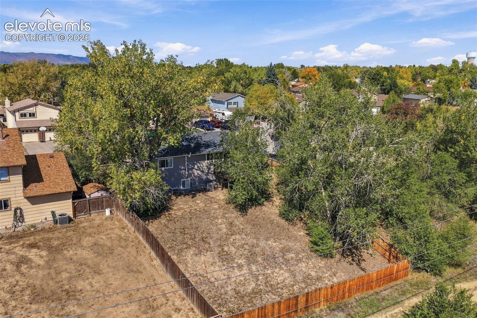 Expansive lot featuring mature trees and a wooden privacy fence