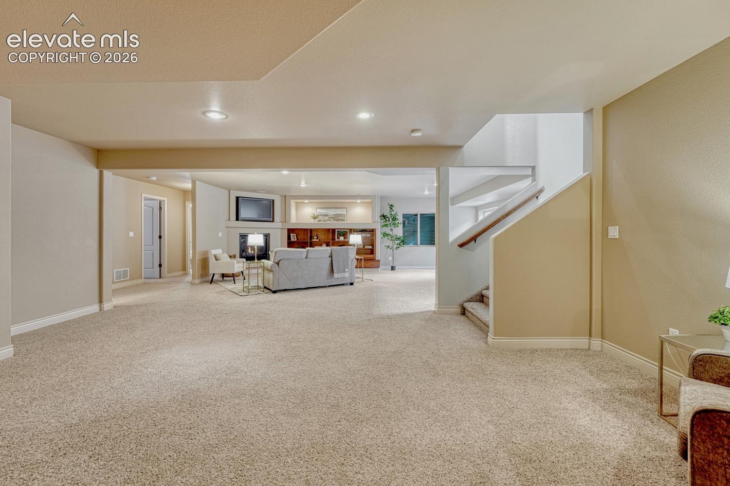 The basement expands the living space with a large family room featuring a fireplace, built-in entertainment center, & wet bar with refrigerator. 