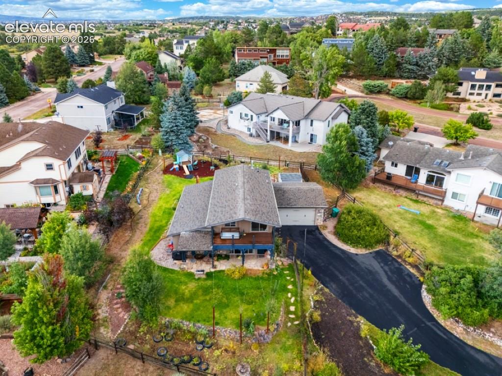 Asphalt driveway, attached garage, sloped backyard, mature trees, multi-level deck