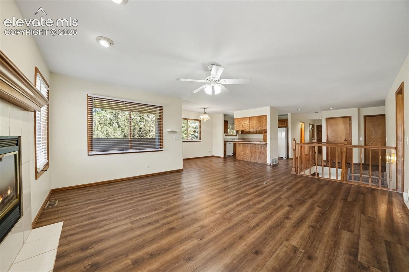Expansive living area featuring new LVP flooring, recessed lighting, and a gas fireplace with a tile surround and wood mantel