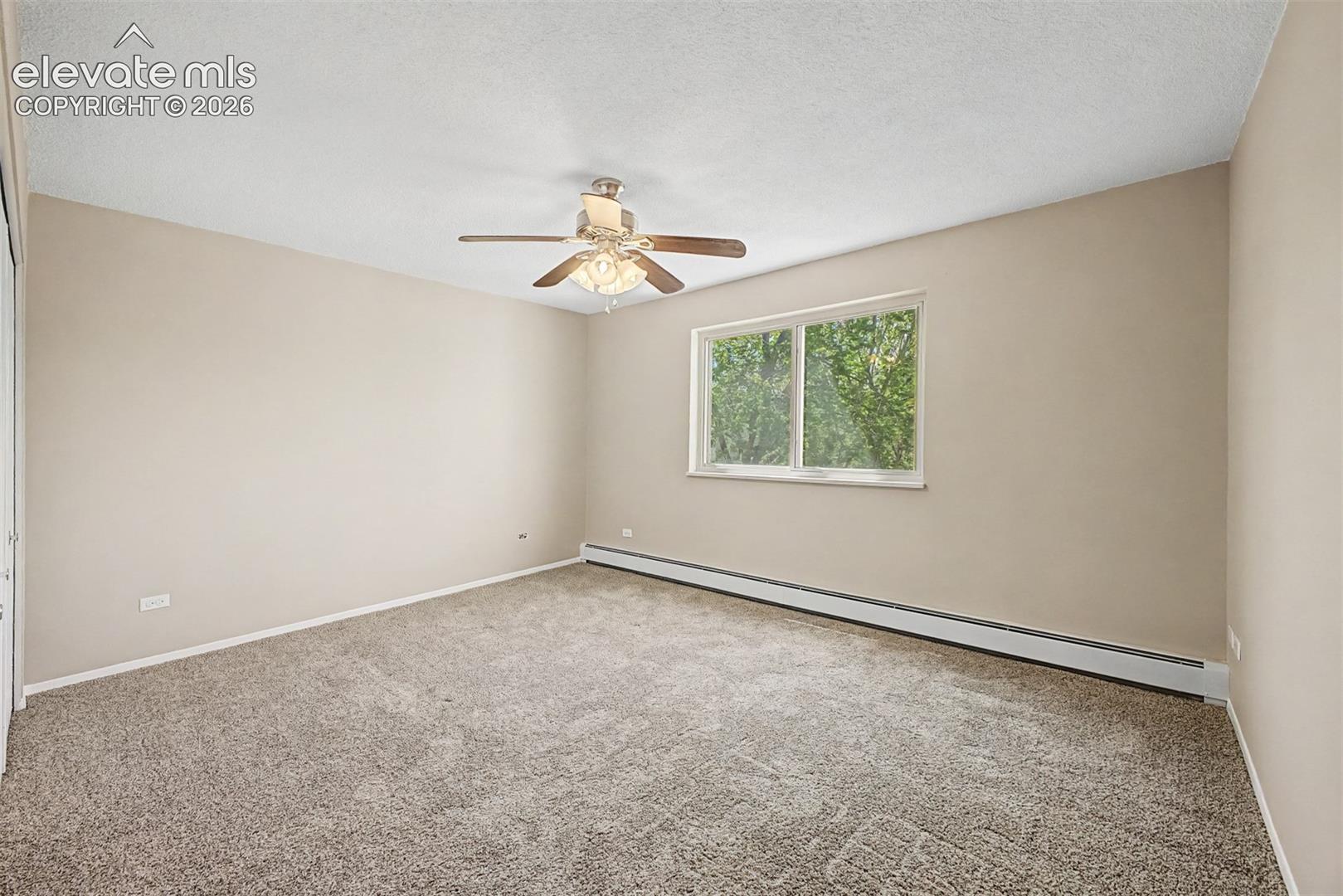 Neutral-toned carpeted room with light beige walls