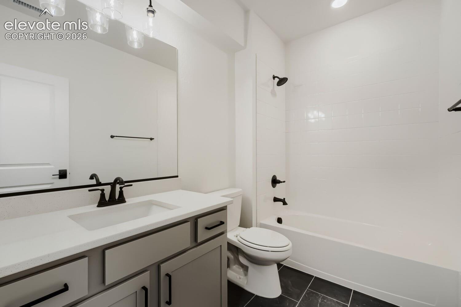 Contemporary bathroom featuring a light gray vanity with a single basin sink, white countertop, and dark-toned hardware