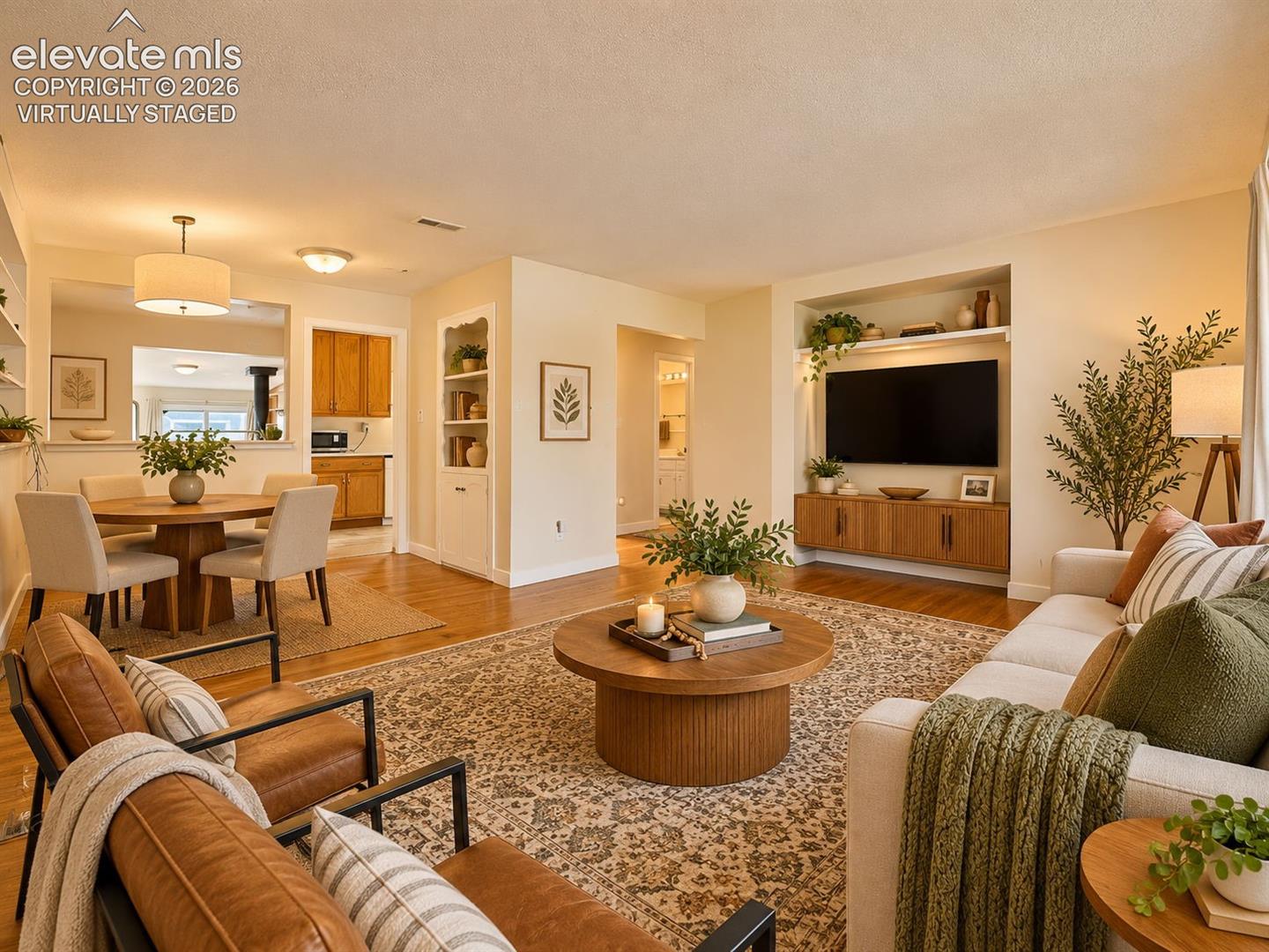 (Virtually Staged)
Comfortable living and dining area featuring hardwood floors, built-in display shelving, and an open layout ideal for everyday living and entertaining.