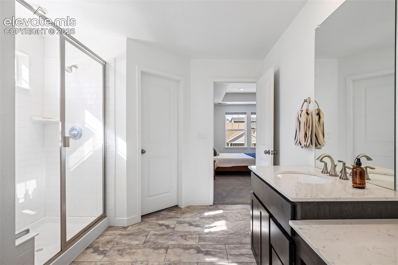 Walk-in shower with clear glass enclosure and subway tile surround