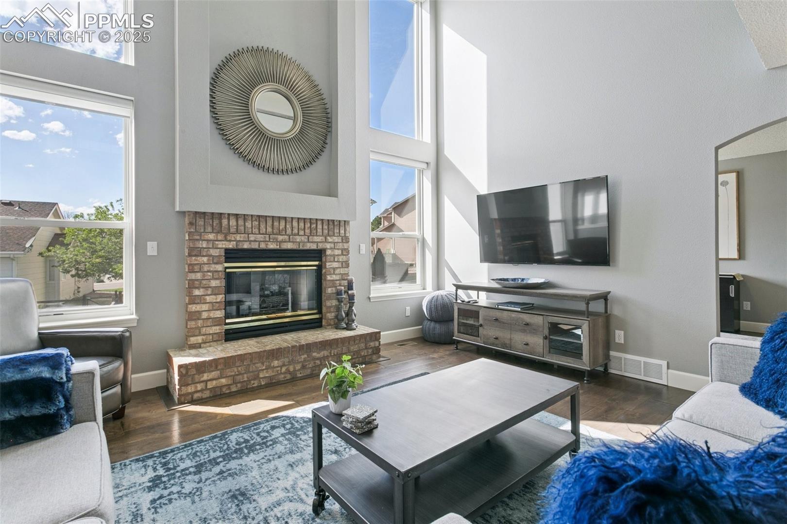 The cozy gas fireplace is framed by four large windows! Roller shades are remote-controlled and offer plenty of filtered light when closed!