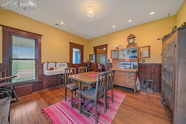 Dining space featuring wainscoting, wood-type flooring, recessed lighting, and wooden walls