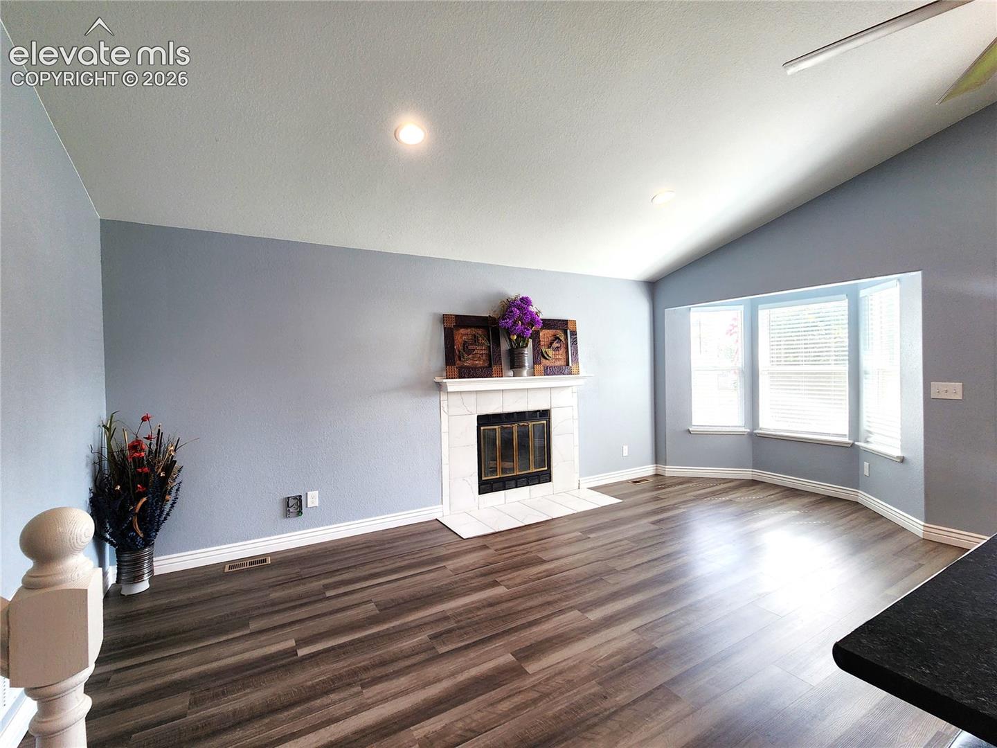 Sun-drenched family room featuring large windows and a cozy abiance
