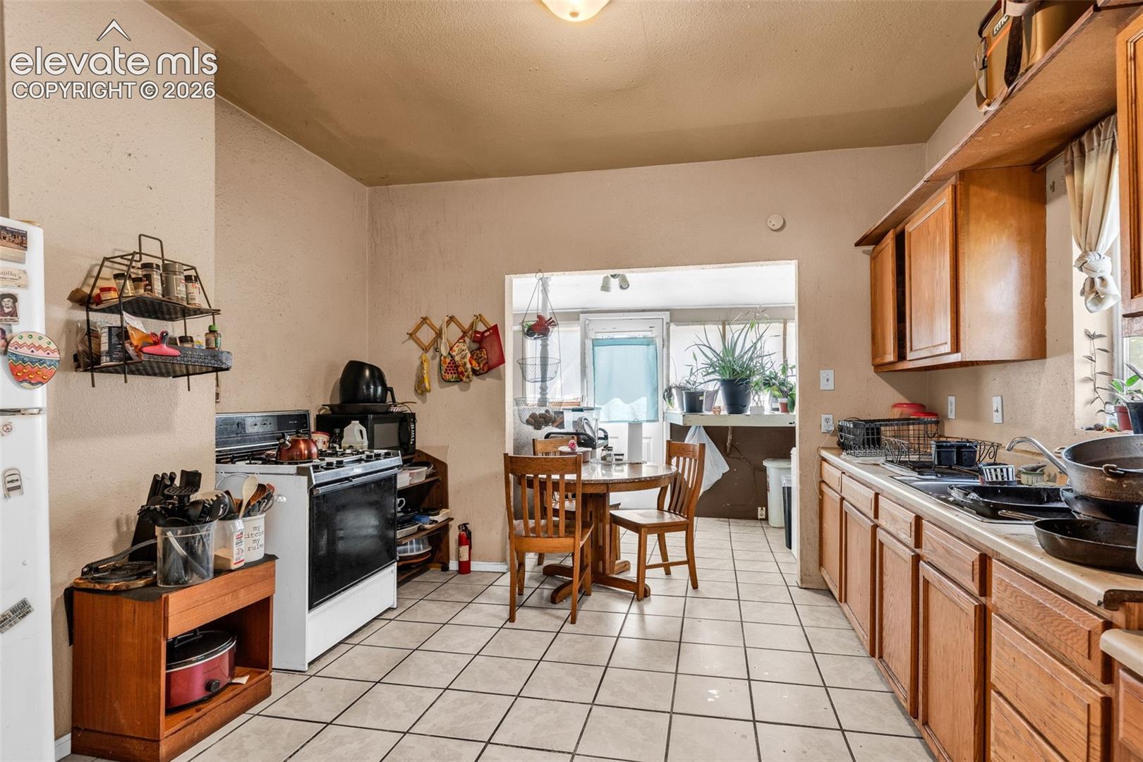 Kitchen featuring tile flooring, wooden cabinetry, and a gas range